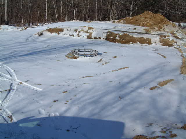 The snow-covered concrete  wind turbine's base.