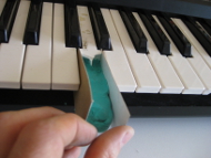 Cardboard sides for the mold to repair the piano/keyboard key.