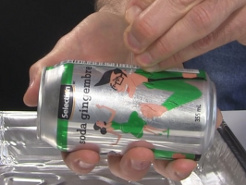 Making a hole in the side of a soda can using a needle.