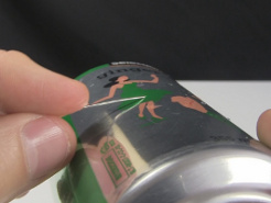 Pulling the needle tangentially to the curvature of the soda can for the other hole.