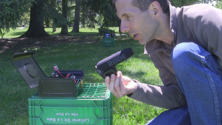 Speaking into the microphone to transmit sound using my DIY/homemade laser communicator and showing the red laser spot on the receiver solar cell in the distance.