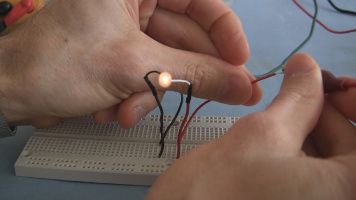 Spiral capacitor dumping its charge through a lightbulb.