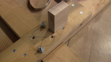 Wood block screwed to cross piece for holding the bottom of the pole.